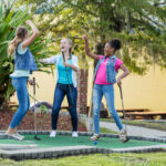Golfers celebrate while playing mini golf